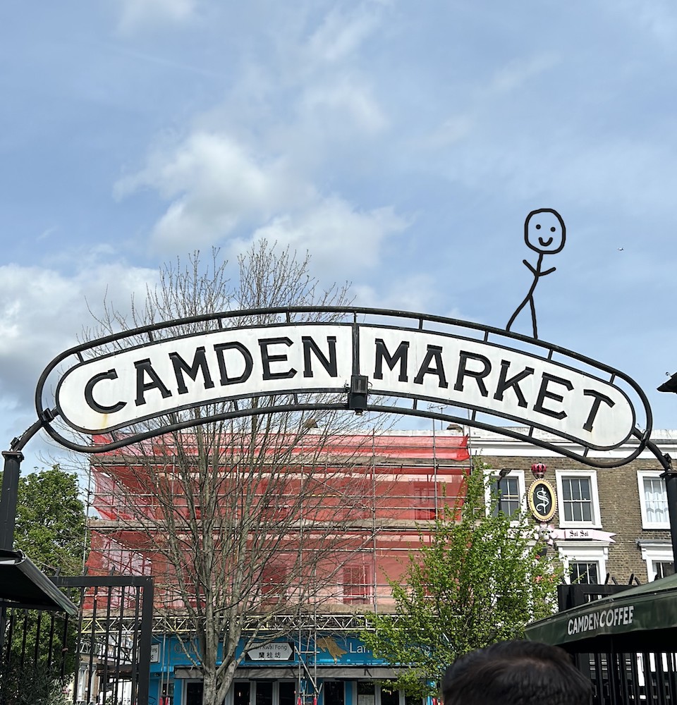 Sign saying 'Camden Market' with a stick figure perched on top